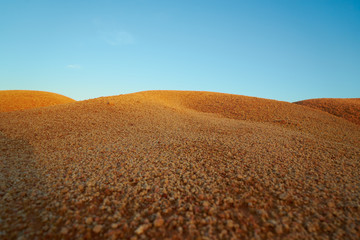 Tropical laterite soil or red earth background. Red mars seamless sand background.with blue sky.