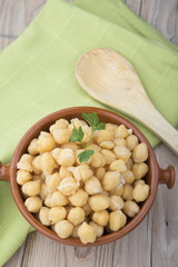 Chickpeas on glass bowl on wooden table