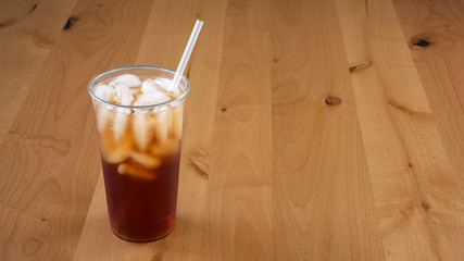 Large Fresh brewed Iced tea in a clear cup with a straw.
