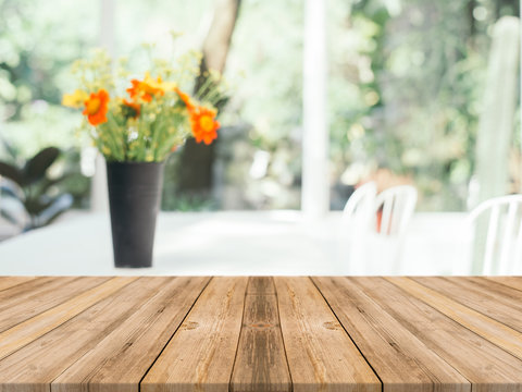 Wooden board empty table blurred background. Perspective brown wood over blur flower vase in coffee shop - can be used for display or montage your products.Mock up for display of product.
