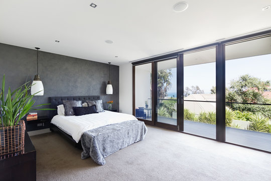 Spacious interior of designer master bedroom in luxury Australia