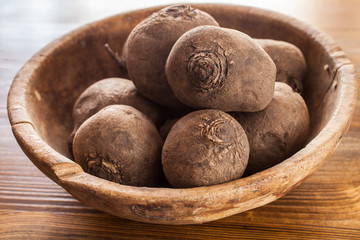 beet in an old wooden bowl on a table, selective focus