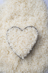 Rice in heart bowl on white rice background