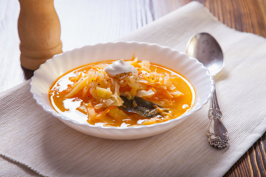 Russian cabbage soup in a plate on a table, selective focus