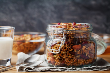 Homemade granola in jar on rustic table, healthy breakfast of oatmeal muesli, nuts, seeds and dried fruit - Powered by Adobe