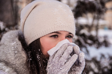 Girl with handkerchief has the flu and running nose winter