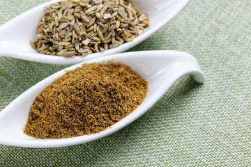 Fennel powder and seeds on texture background