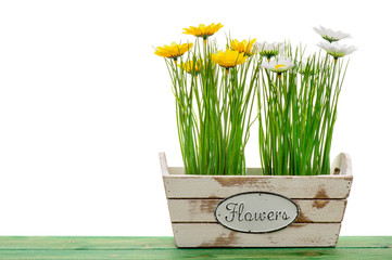 Easter decoration - artificial flowers in the wooden box on the wooden background.