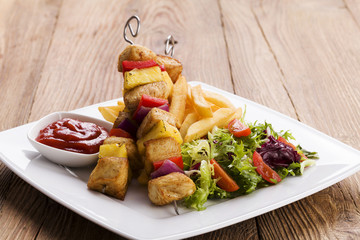 Grilled chicken skewers with pineapple, peppers and onions serve