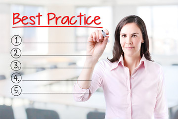 Business woman writing blank Best Practice list. Office background. 