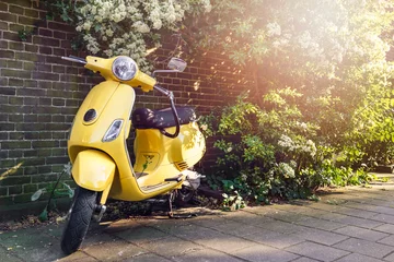 Foto op Plexiglas Scooter Gele scooter geparkeerd