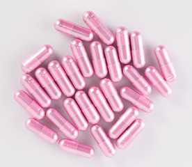 pink pill capsules on white background