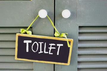 The close up of toilet sign hanging on the door in retro color, Selective focus on the word toilet