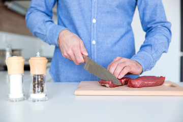 Closeup of fresh meat cutted by man with big knife