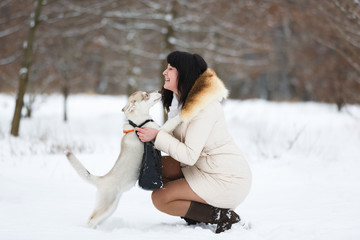 Woman with a gentle husky puppy