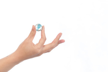 Fototapeta premium Human hand hold glass marbles balls on white blackground, selective focus