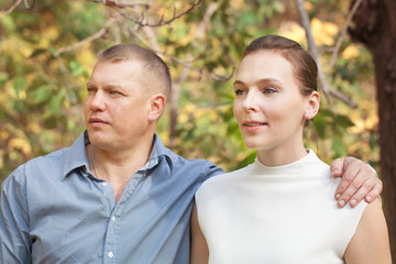 Obraz premium Happy husband embracing wife in autumn park