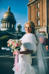 Bride with veil in the city of St. Petersburg in the autumn sunny day