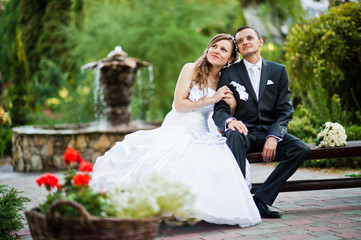 Wedding couple on the yard with ornamental plants and shrubs