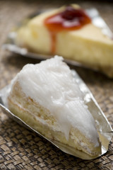 Slice of fresh coconut cake stuffed with cream and and raspberry