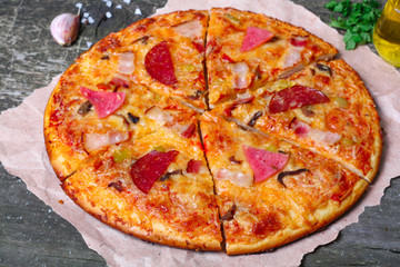 close-up Delicious Meat Pizza with Ham, Bacon and sausages on the wooden background