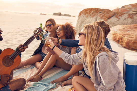 Multi-ethnic friends enjoying beverages on the beach