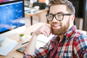 Happy attractive man working and designing project on computer