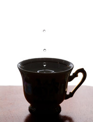 Water drop. Cup of tea with splash. white background. copy space. soft focus, macro view