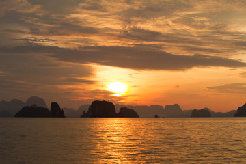Sunrise behind small islands in the sea with low soft light