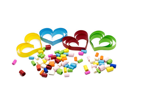 Colorful heart-shaped paper crafts, quilling with small colorful rolls of paper on white background for Valentine's day or love concept