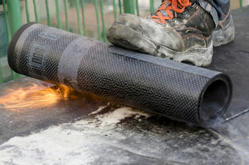 flame during welding of a waterproofing membrane on a roof - obrazy, fototapety, plakaty