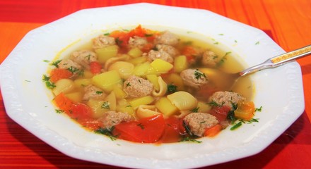 soup with meatballs and pasta in a white plate