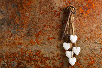 Hearts and key over a rusty metal background with space for text