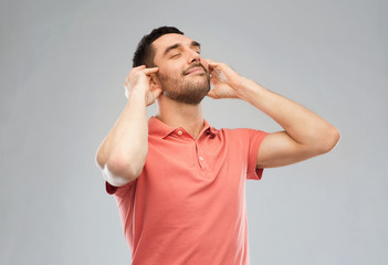 happy man listening to music over gray background