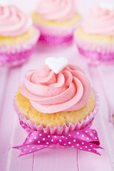 Pink Valentine cupcakes on a rustic pink table