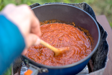 Cooking outdoor on a portable trail stove. Close view.