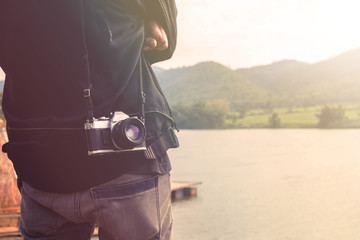 Traveler with vintage camera enjoying lake and mountain view