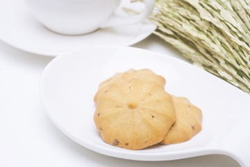 cookies in cup and dry grass on a white background