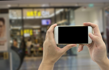 Woman hand shows mobile smartphone and blurred background