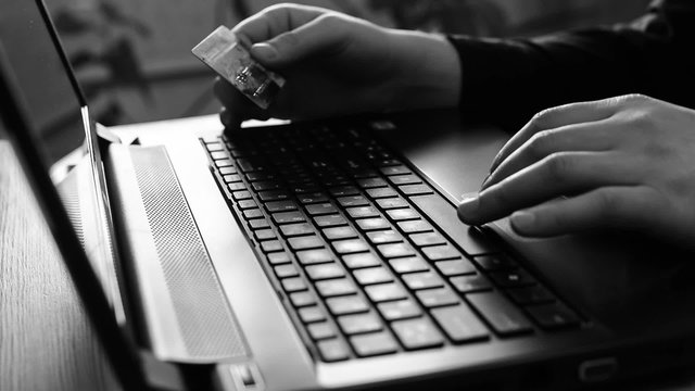 man holding credit card on laptop for online bank concep