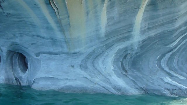 Stunning limestone rock formation with caves looming out of an emerald lake