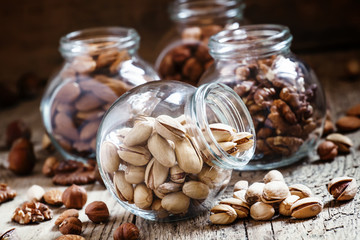 Salted pistachios in a glass jar, nut mix, selective focus