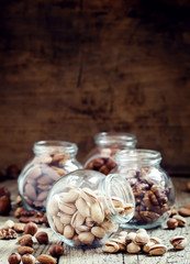 Salted pistachios in a glass jar, nut mix, selective focus