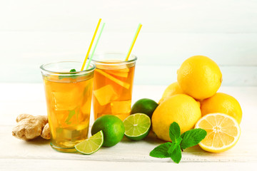 Iced tea with lemon on light wooden background