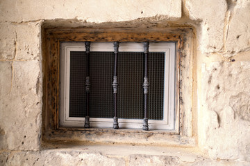 Fototapeta na wymiar Old window with wrought iron of a historic building