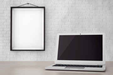 Modern Laptop in front of Brick Wall with Blank Frame