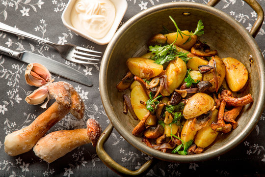 Fried potatoes with mushrooms and onions at home in a frying pan