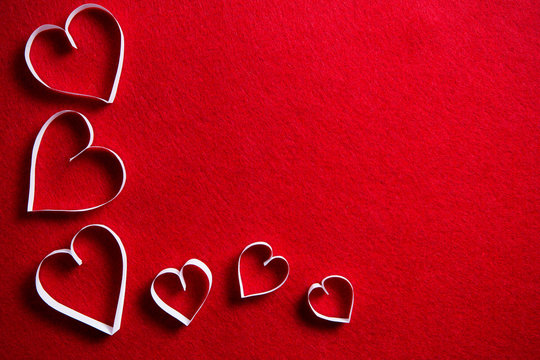 Paper hearts on red background for gift on valentines day.