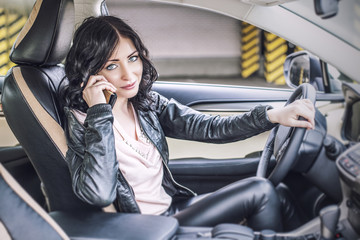 Beautiful sexy female model in leather clothes with a white car