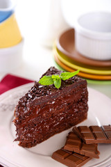 Chocolate cake with chocolate cream on plate, on light background